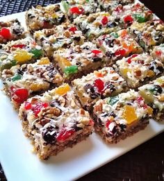 a white plate topped with lots of fruit and granola bars on top of a table