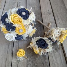 two bridal bouquets sitting on top of a wooden table next to each other