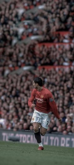 there is a man that is playing soccer in front of an audience on the field