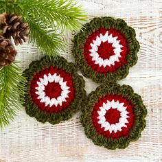 three crocheted coasters sitting on top of a table next to pine cones