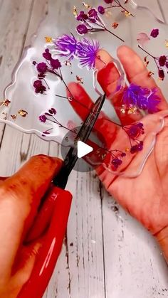 a person cutting flowers with scissors on a table