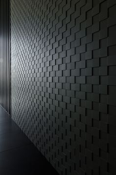 an empty room with black tiles on the wall and flooring in front of it