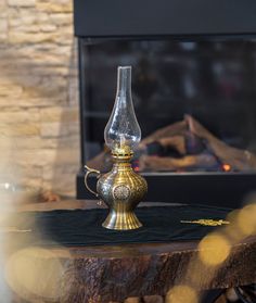 a glass vase sitting on top of a table next to a fire place in front of a fireplace