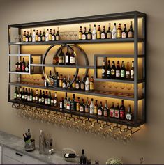 a wall mounted wine rack filled with lots of bottles and glasses next to a counter