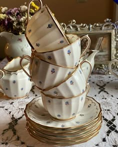 a stack of cups and saucers sitting on top of a table