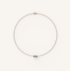 a gold bracelet with an emerald stone on the end and a small bead at the end