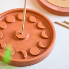 a candle holder made out of clay with candles on it and sticks in the middle