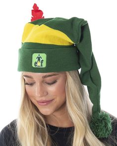 a woman wearing a green and yellow hat with pom - pom on top