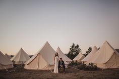 two people sitting in front of some tents