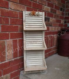 a tall wooden shelf sitting next to a brick wall