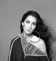 black and white photograph of woman with long hair wearing an off the shoulder top, earrings and necklace