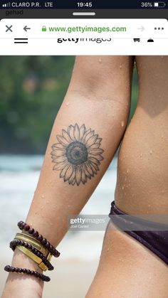 two women's legs with tattoos and bracelets on them, one has a sunflower