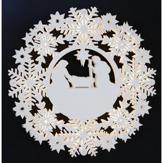 a paper cut nativity scene with snowflakes in the shape of a circle