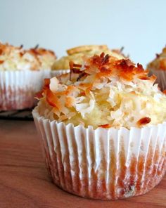 three cupcakes sitting on top of a wooden table