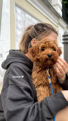 a woman holding a small dog in her arms