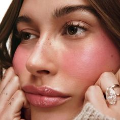 a close up of a person with a ring on her finger and wearing a sweater