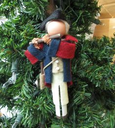 a christmas ornament hanging from a tree with a toy soldier on it's back