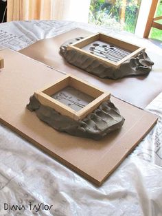 two wooden trays sitting on top of a table