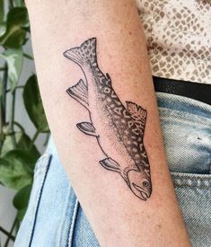 a woman's arm with a fish tattoo on it