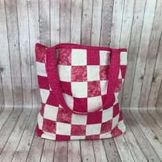 a red and white checkered bag sitting on top of a wooden floor