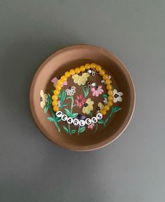 a bowl with beads and flowers on it