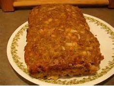 a piece of meatloaf sitting on top of a white and green plate