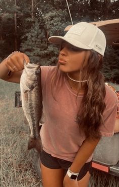 a woman holding a fish in her right hand