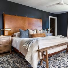 a large bed sitting next to a window in a bedroom on top of a blue rug