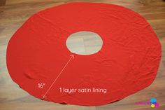 a large red piece of paper sitting on top of a wooden floor next to a ruler