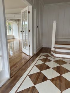 an empty room with wooden floors and white walls, has a checkerboard pattern on the floor