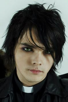 a young man with black hair and green eyes