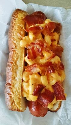 a hot dog covered in cheese and bacon