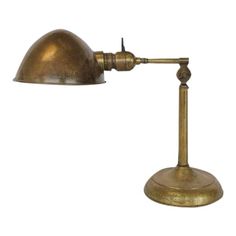 an antique brass desk lamp on a white background