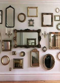 a wall filled with lots of mirrors and frames