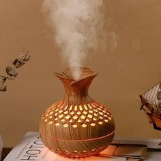 a wooden diffuser sitting on top of a table next to a vase with steam coming out of it