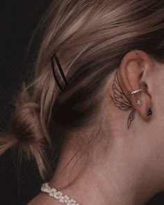 a woman's behind the ear tattoo is shown