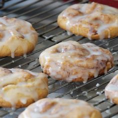 glazed donuts are cooling on a rack in the oven and drizzled with icing