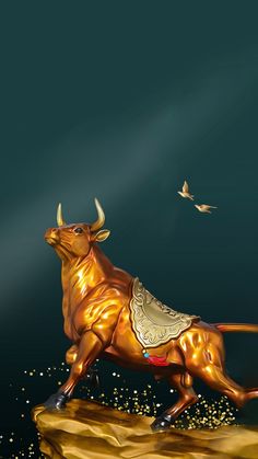 a golden bull statue on top of a rock in front of a bird flying overhead