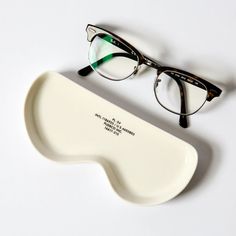 a pair of glasses sitting on top of a white table next to an eyeglass case