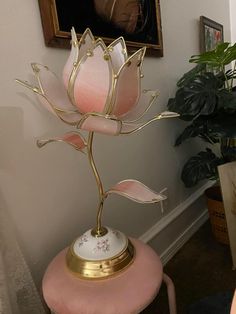 a pink chair with a gold and white flower on it