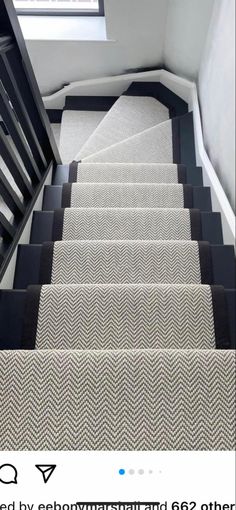 the stairs in this house have black and white carpet on them, but no one is going down it