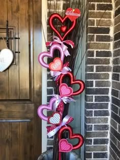 valentine's day decorations are hanging on the front door with heart shaped balloons attached to them