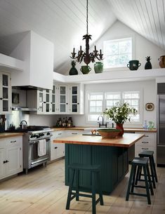 a kitchen with white cabinets and green island