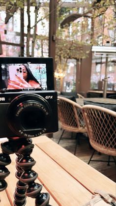 a camera sitting on top of a tripod in front of a dining room table