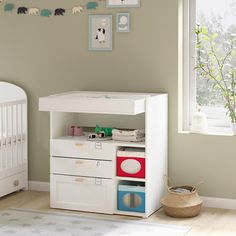 a baby's room with a crib, dresser and changing table in it