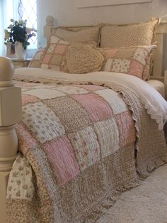 a bed with pink and white quilts in a bedroom