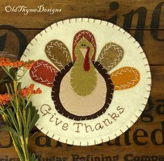 a thanksgiving turkey with the words give thanks on it and some flowers in front of it