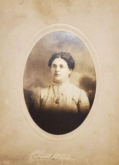 an old photo of a woman with clouds in the background