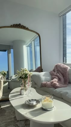 a living room filled with furniture and a large mirror over the top of a table