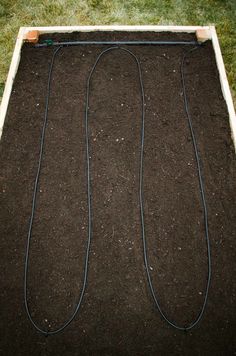 the ground is covered with dirt and some wires are plugged in to the ground